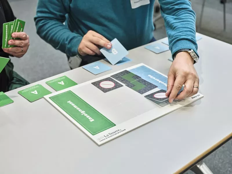 mains-manipulant-des-cartes-sur-un-plateau-de-jeu-la-source