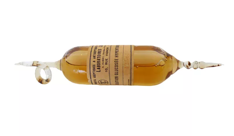 Ampoule de verre soufflé avec solution glucosée hypertonique à 300 pour mille des Laboratoires Leclerc, Paris. Solution colorée avec le temps, étiquette d'origine. Producteur : Aubry A. (c)Archives Fondation La Source