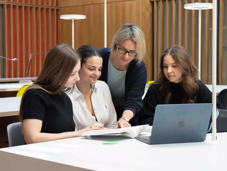 bibliothécaire-de-la-source-qui explique-aux-etudiantes-un-document