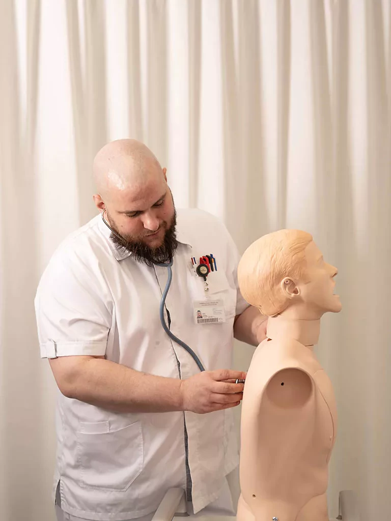 Etudiant infirmier pratique l'évaluation clinique sur un buste