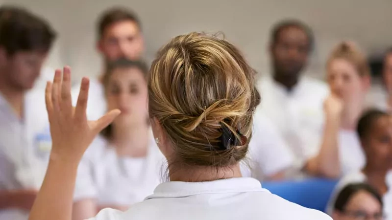 Infirmière de dos parle à étudiants en soins infirmiers